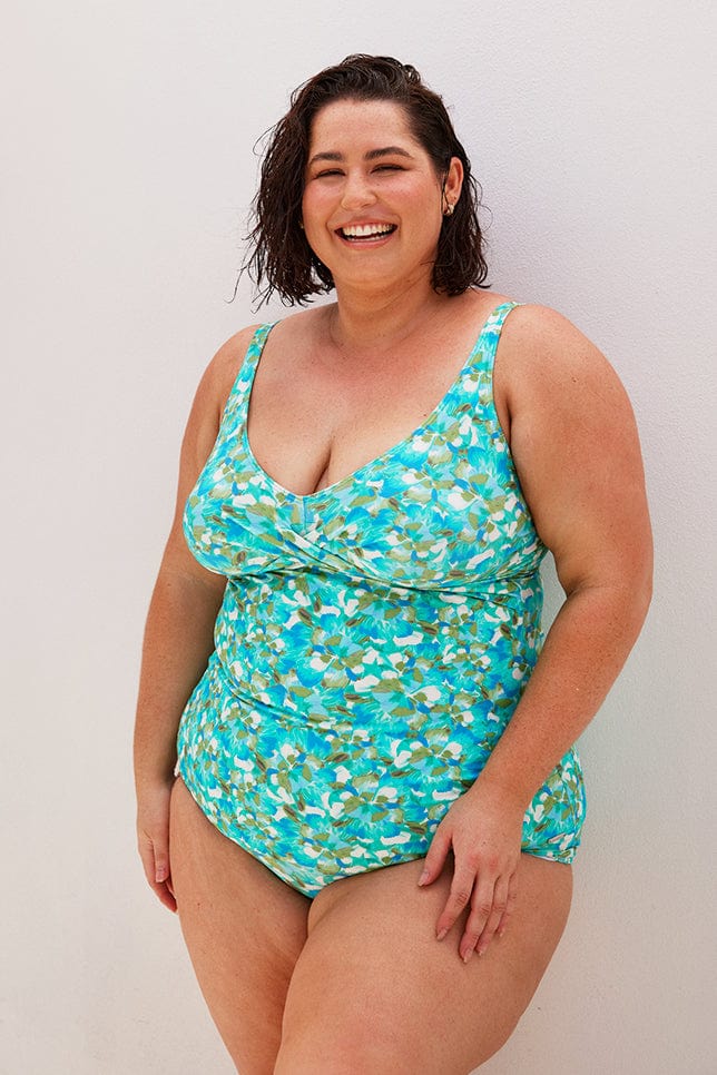 Brunette plus size model wears turquoise blue low neck tankini top