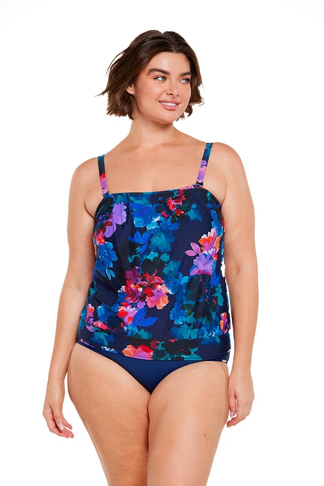 brunette women wears navy blue floral flouncy bandeau tankini top