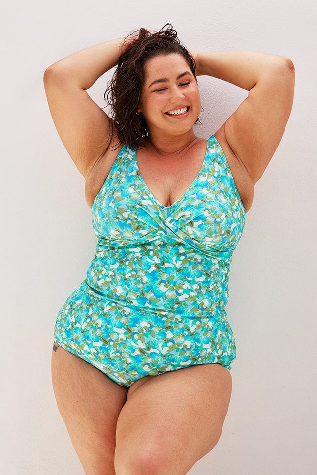 Brunette plus size women wears blue high waisted bikini bottom