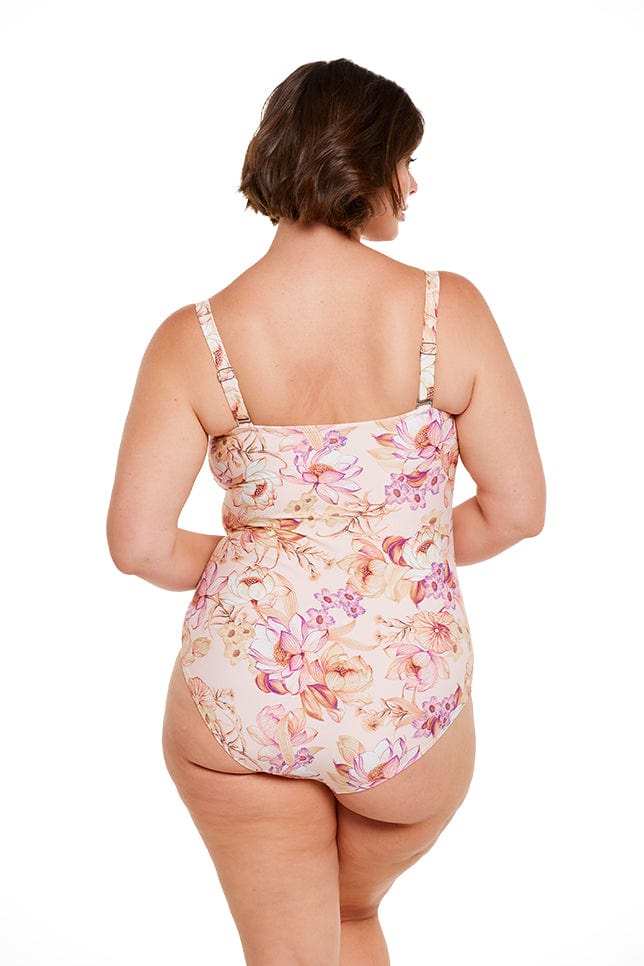 Brunette model wears peach floral strapless bandeau one piece with removable straps