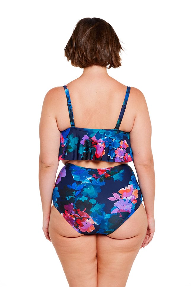 Back of plus size brunette model wearing tiered frill bikini top with adjustable straps in navy floral print