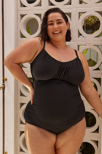 Brunette plus size model wears underwire one piece in textured fabric