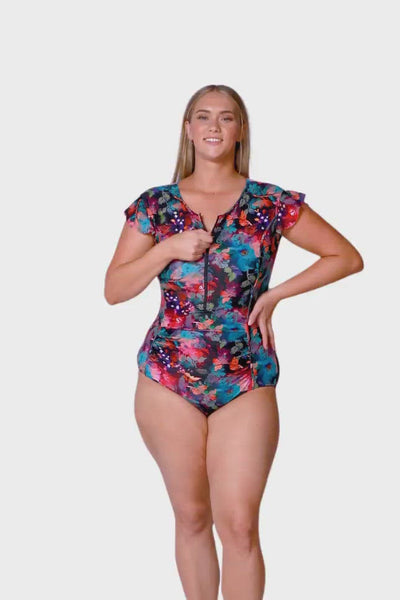 Product Video of blonde size 16 model wearing a frill sleeve one piece with a front adjustable zip and power mesh stomach ruching