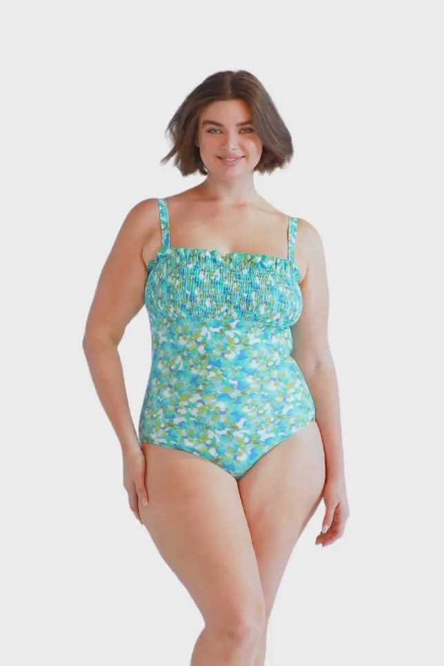 brunette plus size model wears turquoise blue shirred bandeau one piece with removable straps