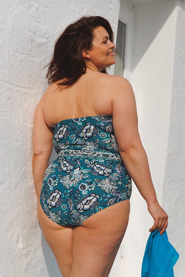 plus size brunette model wearing underwire bandeau one piece with removable straps and adjustable waist tie